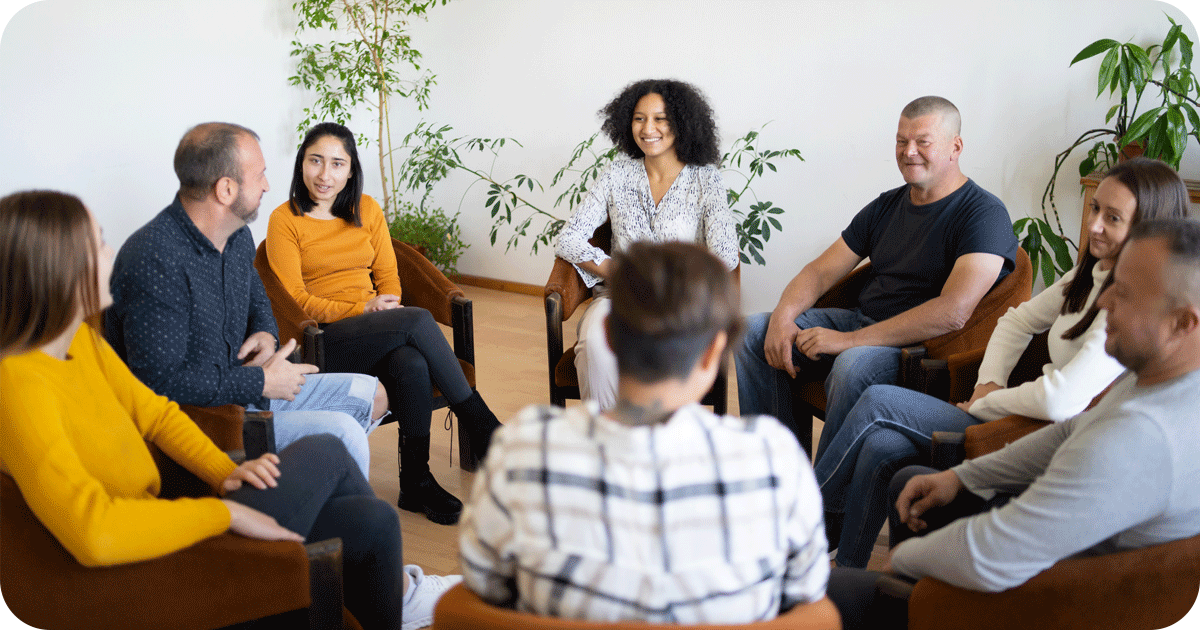 Group therapy session with people supporting each other in recovery